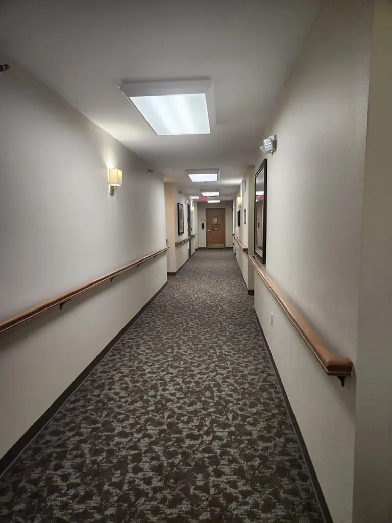 view of community hallway with hand railings